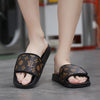 Man wearing VilyVital black leather slide sandals with brown pattern on indoor floor